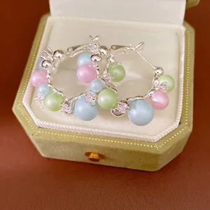 Elegant silver hoop earrings with pastel pearls and crystals in a green velvet gift box.