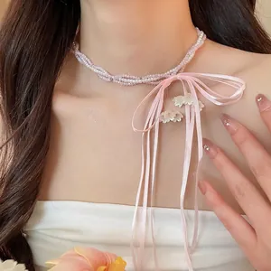 Elegant pink ribbon bow necklace with beaded pearls and floral tassel charms for women