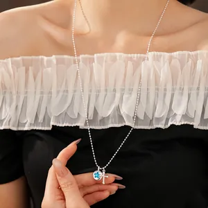 Detailed macro shot of silver ball chain necklace with blue star and cross pendants for women
