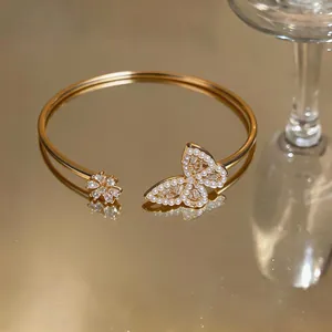 Close-up of gold open cuff bracelet featuring pearl and zircon butterfly design