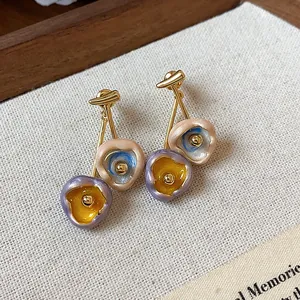 Detailed macro view of colorful oil-dripped enamel earrings with 18k gold plating finish