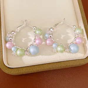 Close-up of multi-colored pastel pearl hoop earrings with crystal accents in a jewelry box