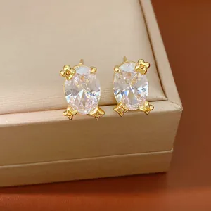 Detailansicht von 18 Karat vergoldeten ovalen Zirkon-Ohrringen mit Monogramm-Blumen