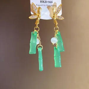 Eleganti orecchini in argento con farfalla di strass e nappe in bambù di resina verde