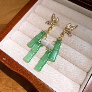 Eleganti orecchini a bambù dorati con nappe in resina verde e strass