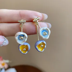 Detailed shot of unique asymmetric drip oil floral earrings with 18k gold plating