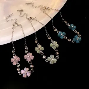 Eleganti bracciali a fiori in occhio di gatto rosa, verde e blu con dettagli scintillanti.