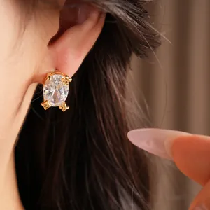 Nahaufnahme der minimalistischen 18 Karat vergoldeten Silber-Zirkonia-Ohrstecker für Damen
