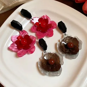 Pendientes de flores retro de acrílico con pieza superior geométrica negra facetada elegante