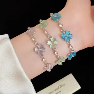 Dettaglio di braccialetti a fiori in pietra occhio di gatto con strass sul polso della modella