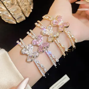 Macro view of elegant sparkling zircon butterfly double-layered open bracelets on a wrist.