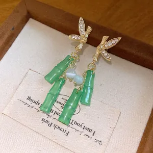 Vista dettagliata di orecchini a nappa in bambù resina verde con accenti di strass.
