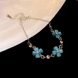 Vista dettagliata di un braccialetto a fiore in pietra occhio di gatto con strass e catena d'argento.