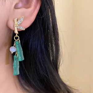 Primo piano di un elegante orecchino a bambù con resina verde e strass scintillanti