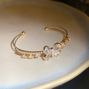 Close-up of elegant golden double-layer cuff bracelet featuring a zircon butterfly motif