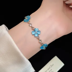 Primo piano di un elegante bracciale a fiore in pietra occhio di gatto blu e argento