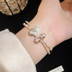 Detailed macro view of a golden double-layered cuff bracelet featuring a zirconia butterfly