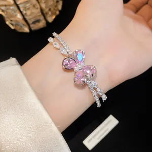 Detailed view of a double-layered silver bracelet with a pink zircon butterfly