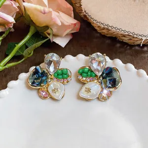 Dettaglio degli orecchini a fiore colorati con pietre preziose miste e cristalli luminosi