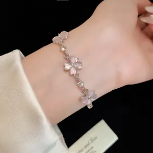 Dettaglio del bracciale con fiori in pietra occhio di gatto rosa e accenti di cristallo