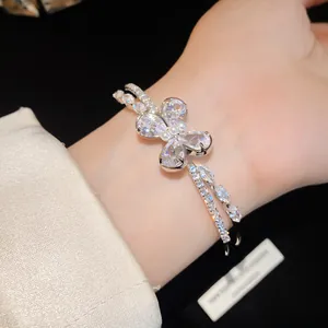 Close-up of a sparkling zircon butterfly double-layer open bracelet on wrist.