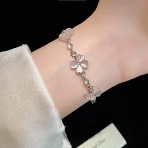 Primo piano di un elegante bracciale a fiori in occhio di gatto rosa con strass al polso