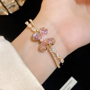 Close-up of elegant double-layered gold bracelet with pink zircon butterfly