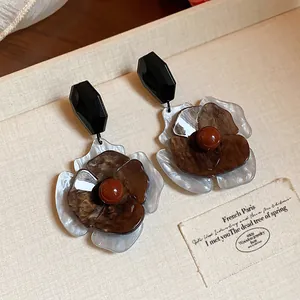 Detalle de pendientes de flores de acrílico retro con pétalos multicapa y cuenta