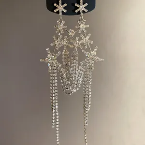 Close-up view of sparkling rhinestone star tassel earrings with long dangling chain details