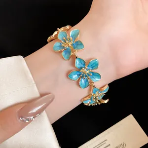 Dettaglio di un braccialetto floreale vintage con petali in smalto blu
