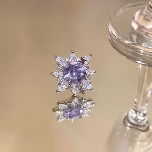Elegant purple zircon flower ear cuff for non-pierced ears on reflective surface.