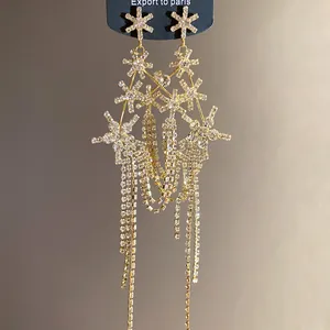 Detail view of gold tassel earrings featuring sparkling rhinestone starburst clusters