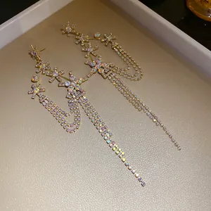 Detailed view of long tassel earrings with sparkling iridescent rhinestones and star motifs.