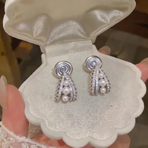 French vintage pearl drop clip-on earrings displayed in a shell jewelry box