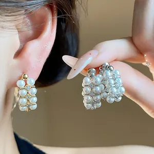 Close-up detail of French retro pearl earrings with silver needles and zircons