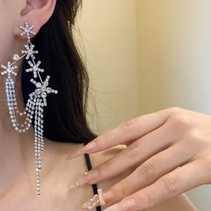 Detailed close-up of elegant silver-toned earrings with sparkling rhinestone star tassels