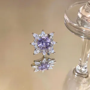 Macro detail of a purple zircon flower ear clip with marquise-cut stones and star accents