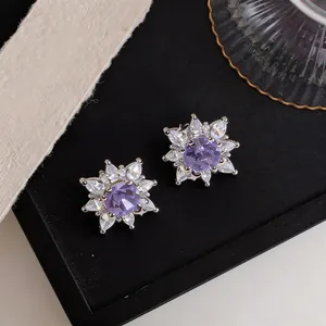 Detailed macro view of purple zircon flower clip-on earrings with sparkling petals