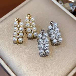 Close-up view of elegant pearl and zircon stud earrings with French vintage aesthetic design