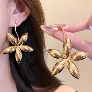 Detailansicht glänzender goldener fünfblättriger Blumenohrringe für modebewusste Frauen