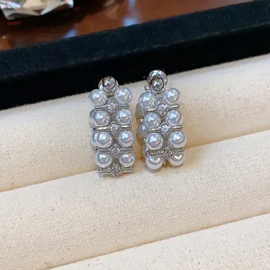 Close-up detail of vintage French style stud earrings with silver needles, zircons and pearls
