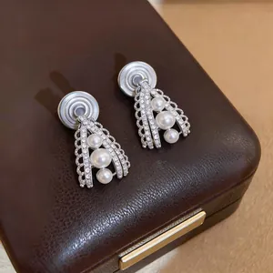 Close-up of French vintage palace style pearl clip-on earrings on a leather box
