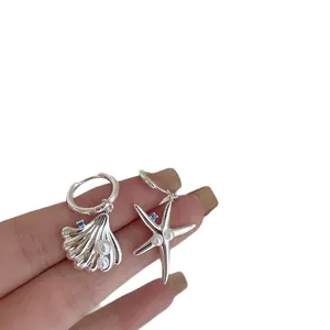 Orecchini asimmetrici in argento con ciondoli a conchiglia e stella marina e perle.