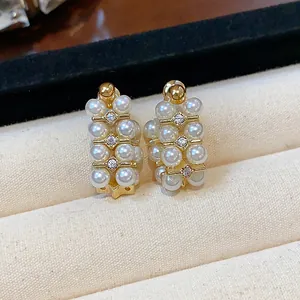 Detailed macro view of elegant French vintage gold pearl earrings with zircon accents
