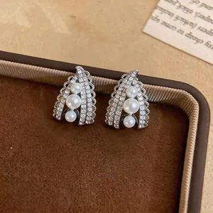 Detailed macro view of French vintage pearl drop clip-on earrings with cubic zirconia stones