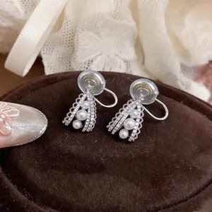 Detailed view of vintage palace style pearl and rhinestone water drop ear clips