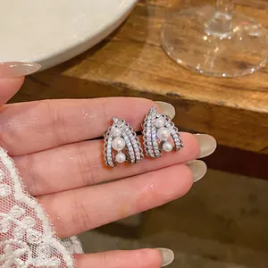 Close-up of French vintage clip-on earrings with pearls and crystals.