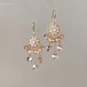 Bohemian ethnic style tassel earrings featuring pink crystals and gold filigree accents
