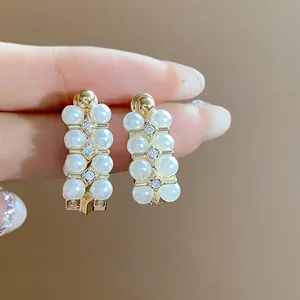 Detailed macro view of French vintage earrings featuring white pearls and sparkling zircons