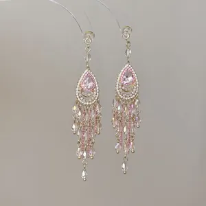 Elegant pink teardrop chandelier tassel earrings featuring shimmering crystal bead accents.